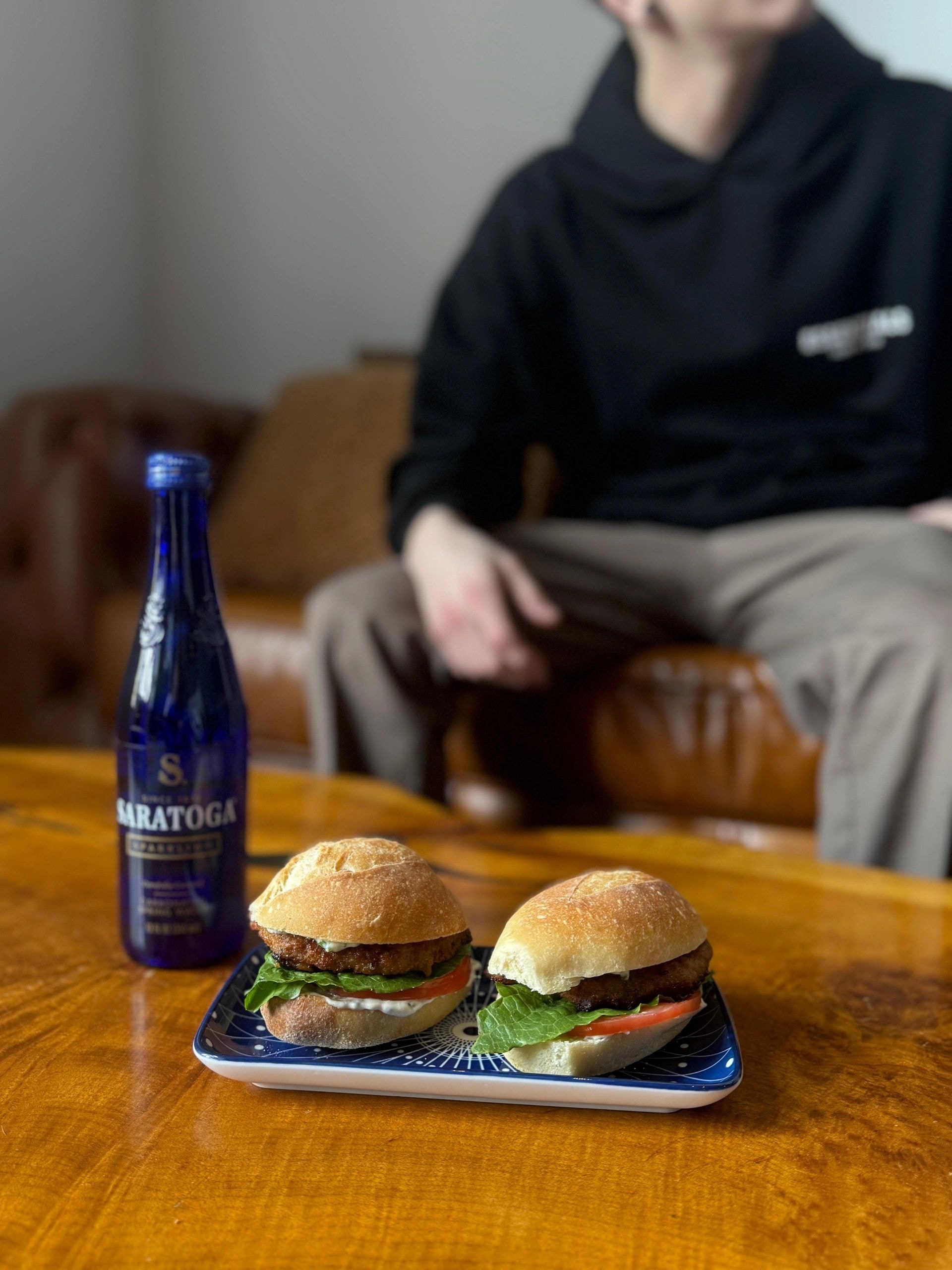 Gourmet burgers and Saratoga bottle on wooden table