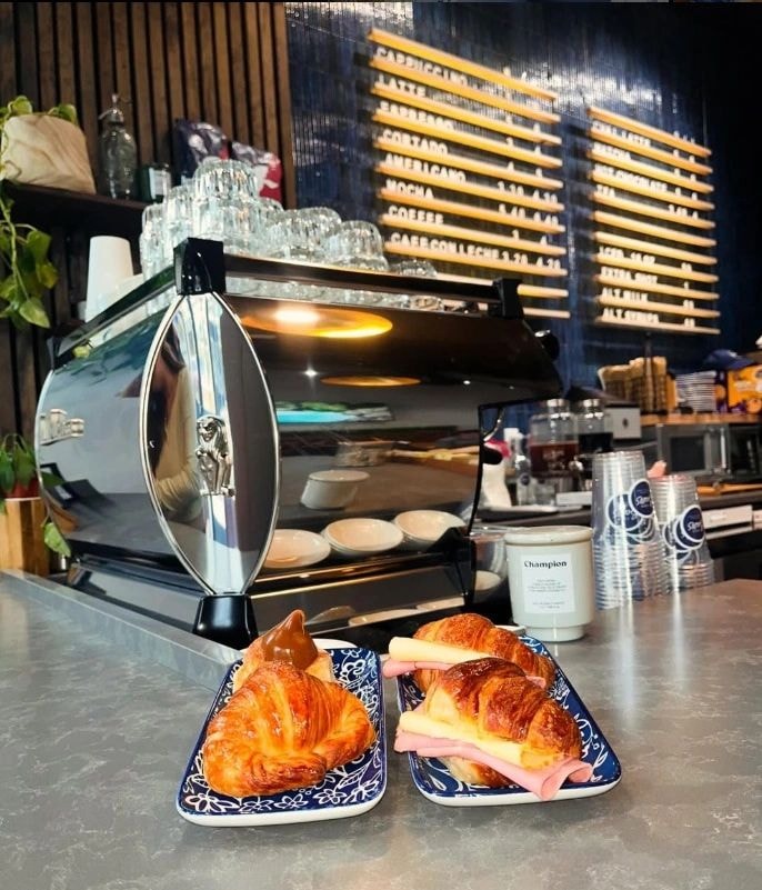Café counter with croissants and espresso machine